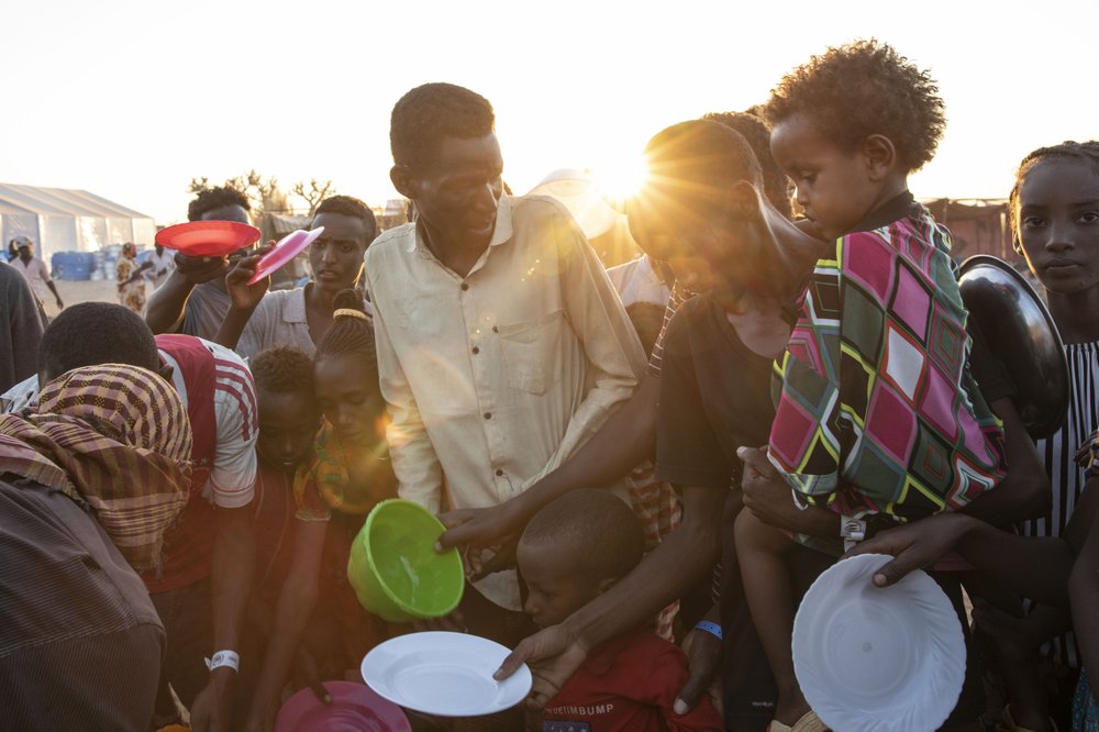 Tigray refugees who fled the conflict in Ethiopia’s Tigray region, wait to get cooked rice served by Sudanese local volunteers at Um Rakuba refugee camp in Qadarif, eastern Sudan, Monday, Nov. 23, 2020.