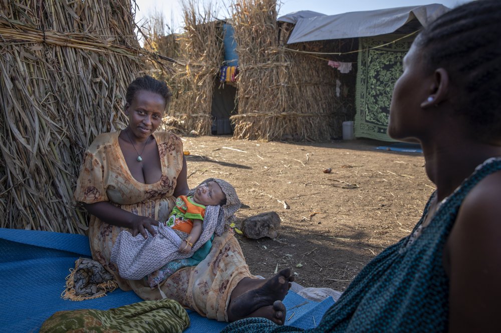 Lemlem Haylo Rada, 25, who fled the conflict in Ethiopia’s Tigray region, holds her one-month old baby in front of her shelter, at Um Rakuba refugee camp in Qadarif, eastern Sudan, Monday, Nov. 23, 2020.