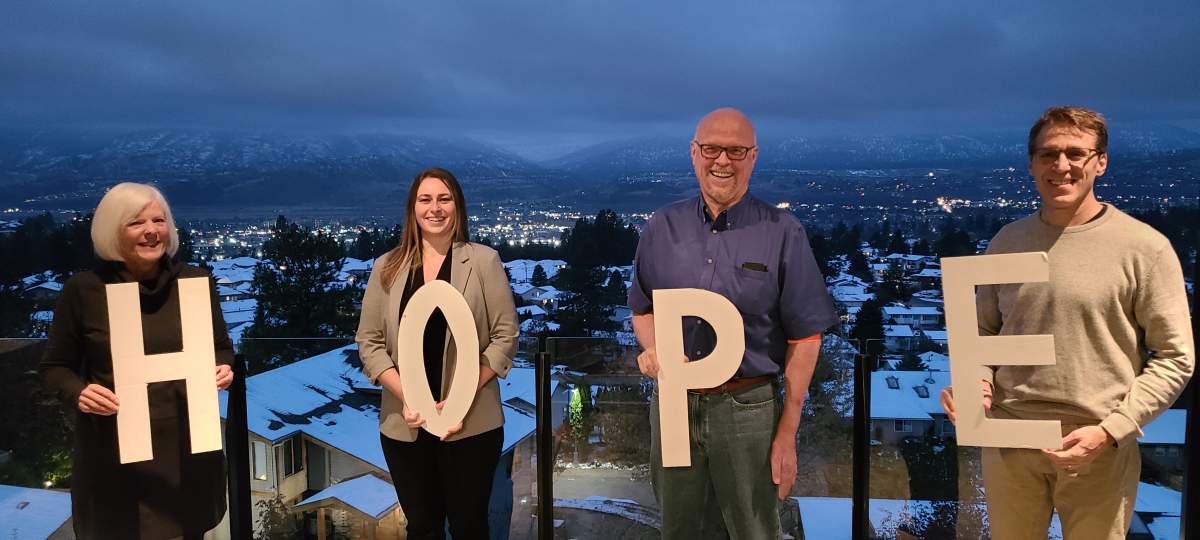 Dr. Harries stands with his colleges with the letters H O P E