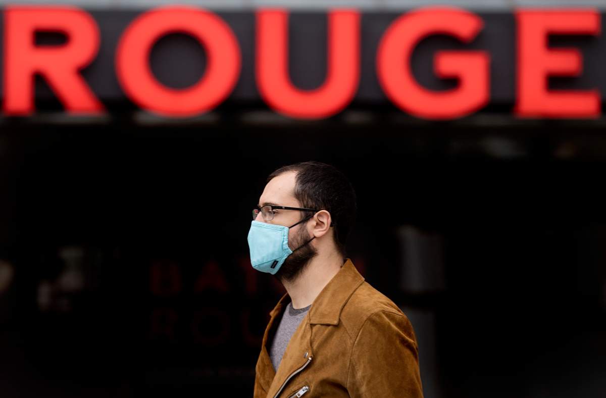 A man wears a face mask as he walks by the word Rouge in Montreal, Saturday, Oct. 10, 2020, as the COVID-19 pandemic continues in Canada and around the world. 