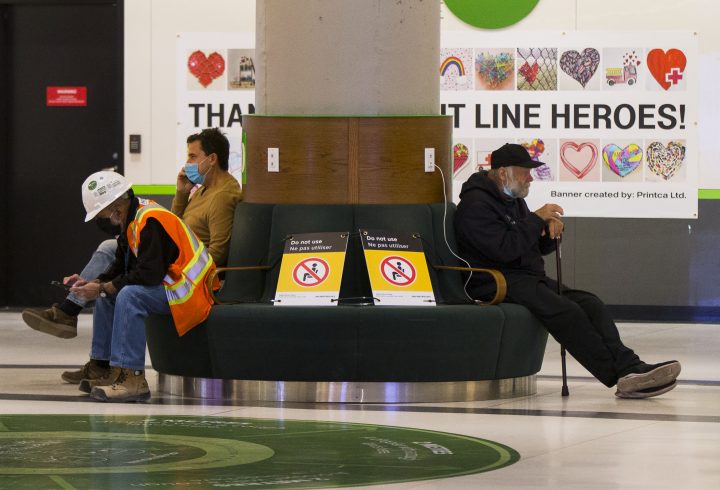 People sit with a physical distance in the waiting room of Union Station in Toronto on Oct. 19, 2020.