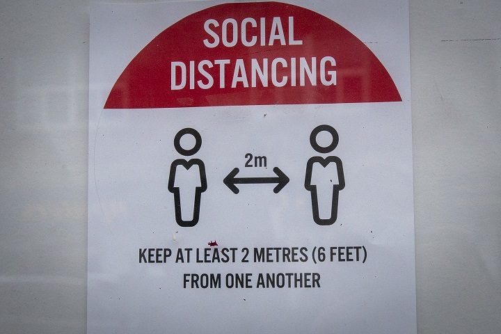 A sign telling people to social distance in Kingston, Ont., on Thursday, Oct. 22, 2020.