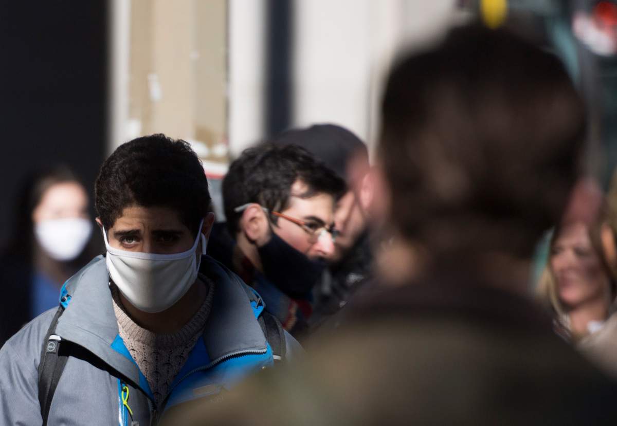 People wear face masks as they walk along a street in Montreal, Saturday, Oct. 31, 2020, as the COVID-19 pandemic continues in Canada and around the world. 