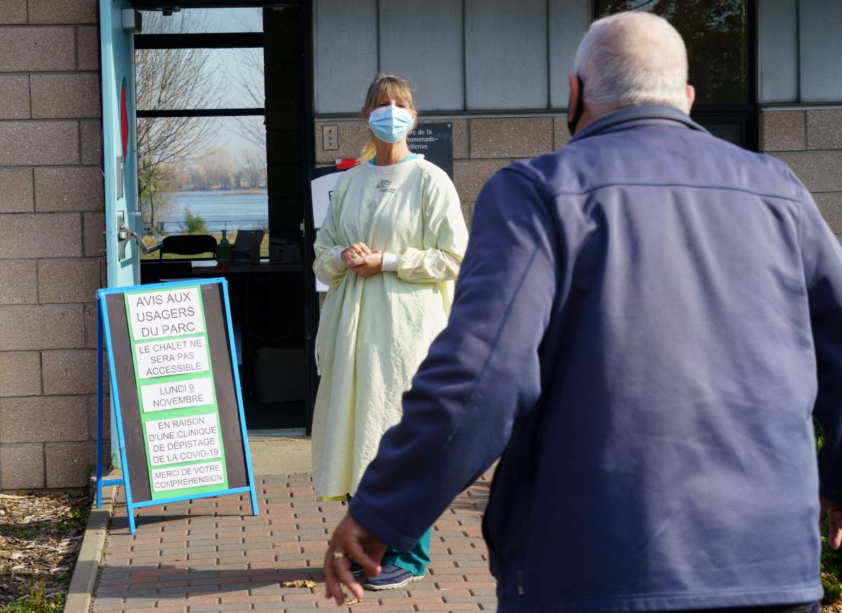 A nurse welcomes a man at a COVID-19 testing clinic in Montreal, on Monday, November 9, 2020. 