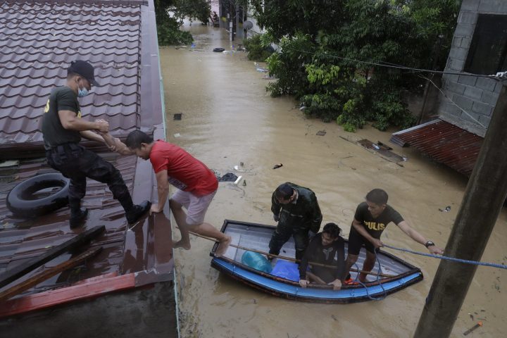 Police rescue residents as floods continue to rise in Marikina, Philippines, due to Typhoon Vamco Thursday, Nov. 12, 2020. A typhoon swelled rivers and flooded low-lying areas as it passed over the storm-battered northeast Philippines, where rescuers were deployed early Thursday to help people flee the rising waters. 