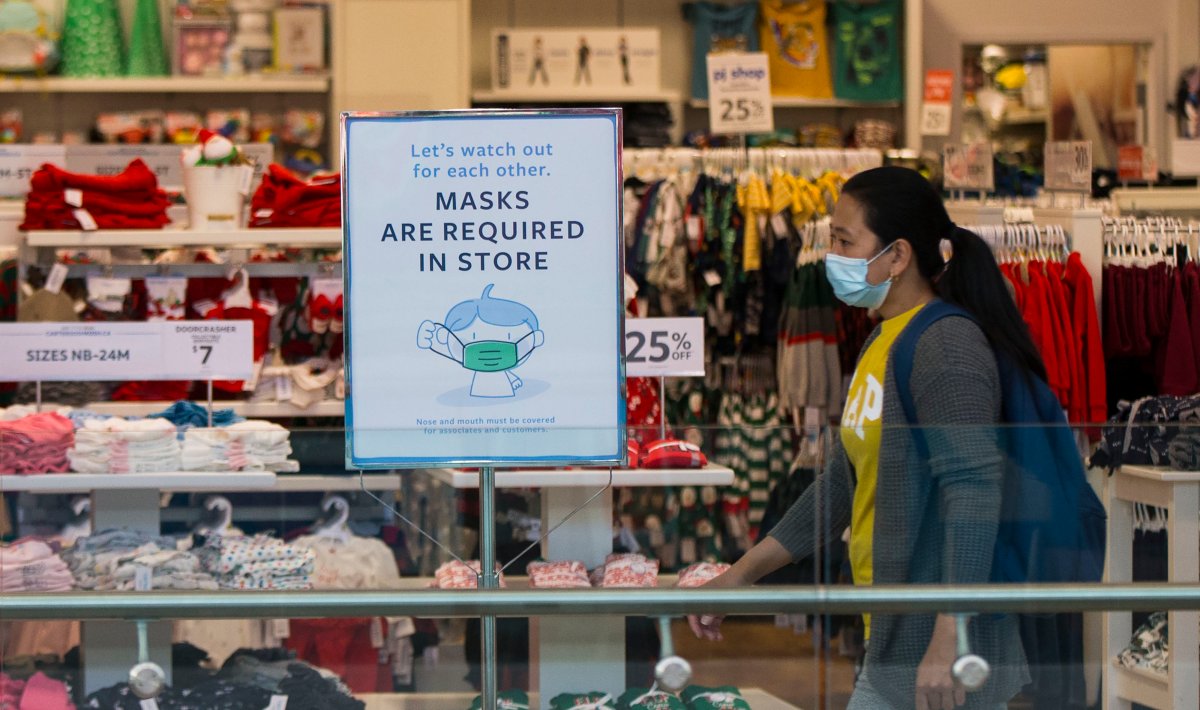 TORONTO, Nov. 10, 2020 A woman wearing a face mask walks past a store with a notice of mandatory mask requirement in Toronto, Canada, on Nov. 10, 2020.