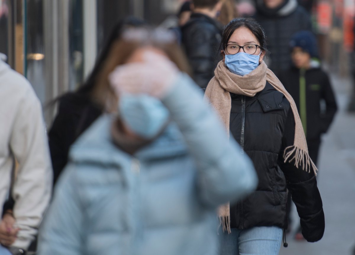 People wear face masks as they walk along a street in Montreal, Saturday, Nov. 21, 2020, as the COVID-19 pandemic continues in Canada and around the world.