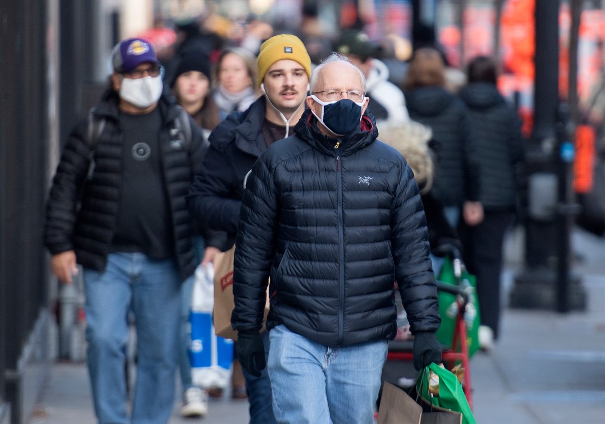 People wear face masks as they walk along a street in Montreal, Saturday, Nov. 21, 2020, as the COVID-19 pandemic continues in Canada and around the world.