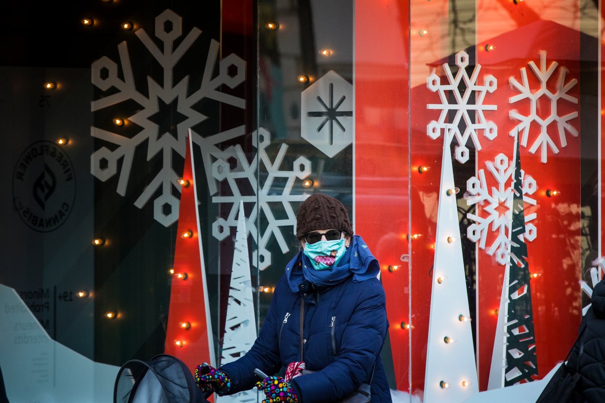 A person wears a disposable mask as they walk by a Christmas decoration in a store in Kingston, Ontario on Tuesday, November 24, 2020, as the COVID-19 pandemic continues across Canada and around the world. 