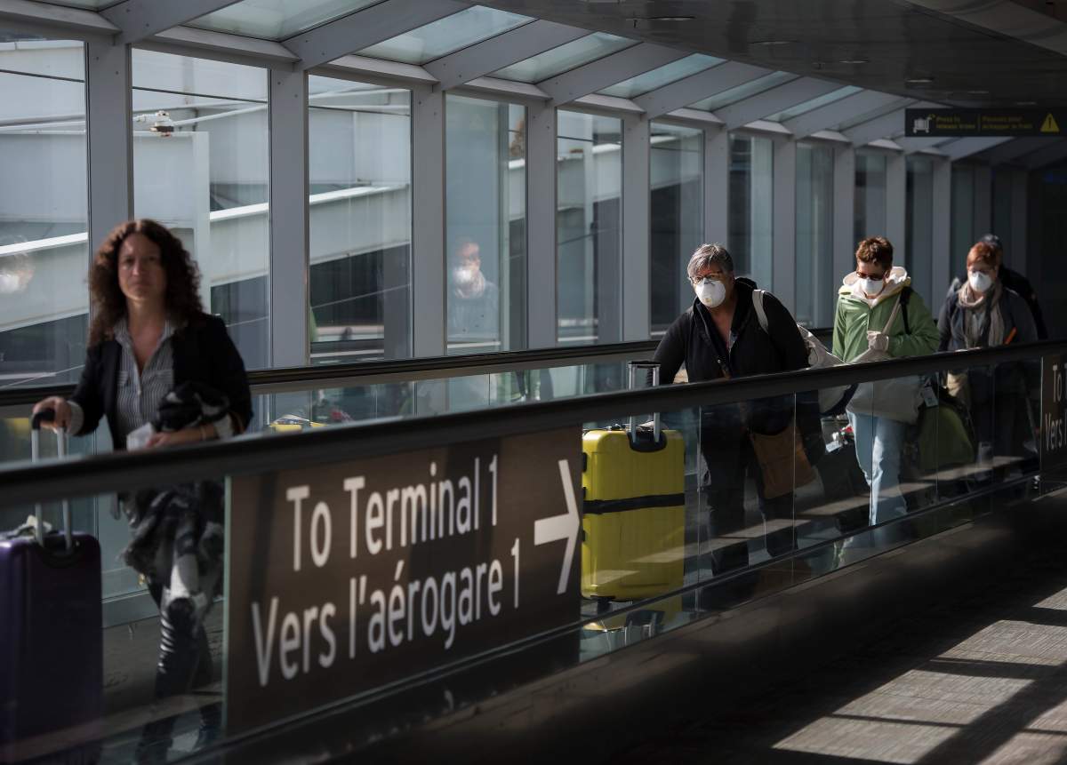 People leave after arriving at Pearson International Airport in Toronto on Monday, March 16, 2020.