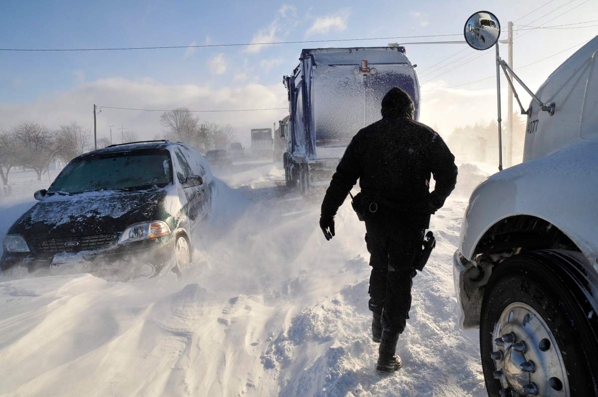 A Sarnia police officer checks on stranded motorists on London Line, East of Sarnia, Ont., on Tuesday Dec. 14, 2010.