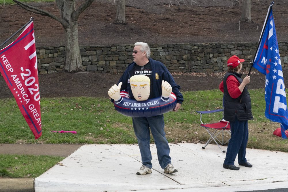 Protesters demonstrate as United States President Donald Trump arrives at Trump National Golf Club on Nov. 21, 2020.