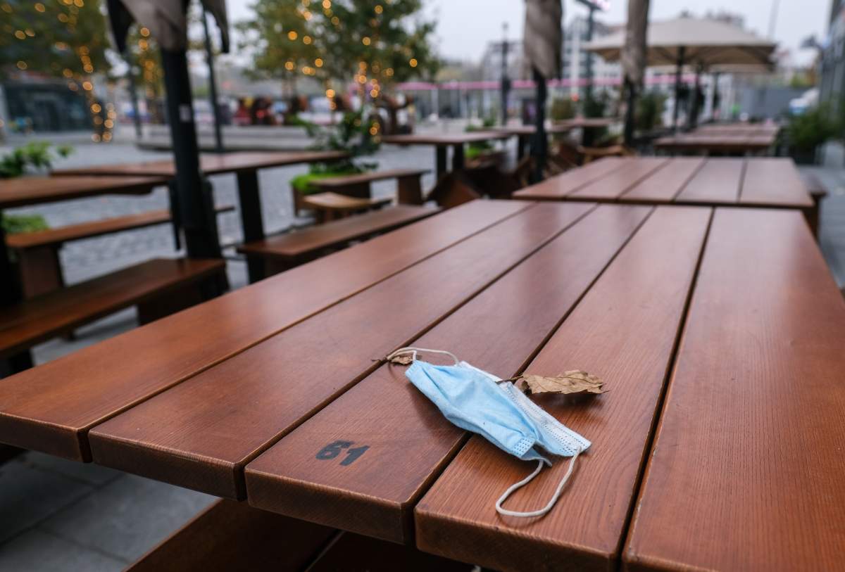 09 November 2020, Berlin: A mouth and nose protector is lying on an empty table in front of a restaurant on Mercedes Square. Federal and state governments have decided on a partial lockdown for November. Food may only be sold to go. Sitting in front of and in the restaurant or snack bar is not allowed. Photo: Jens Kalaene/dpa-Zentralbild/ZB (Photo by Jens Kalaene/picture alliance via Getty Images).