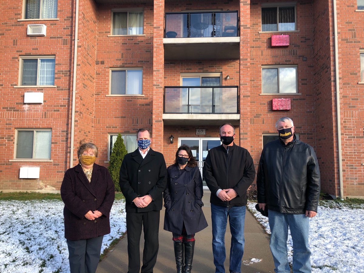 From left to right: Aylmer Mayor Mary French, Environment Minister Jeff Yurek, St. Thomas director of social services Heather Sheridan and Joe and Peter Ostojic of Walter Ostojic and Sons Ltd. stand in front of 69 Brown St., an apartment building that the new project will take inspiration from.