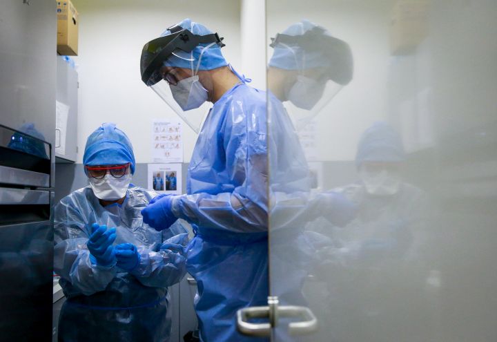 (FILE PHOTO) A nurse dresses in protective clothing to be able to care for a COVID-19 patient.