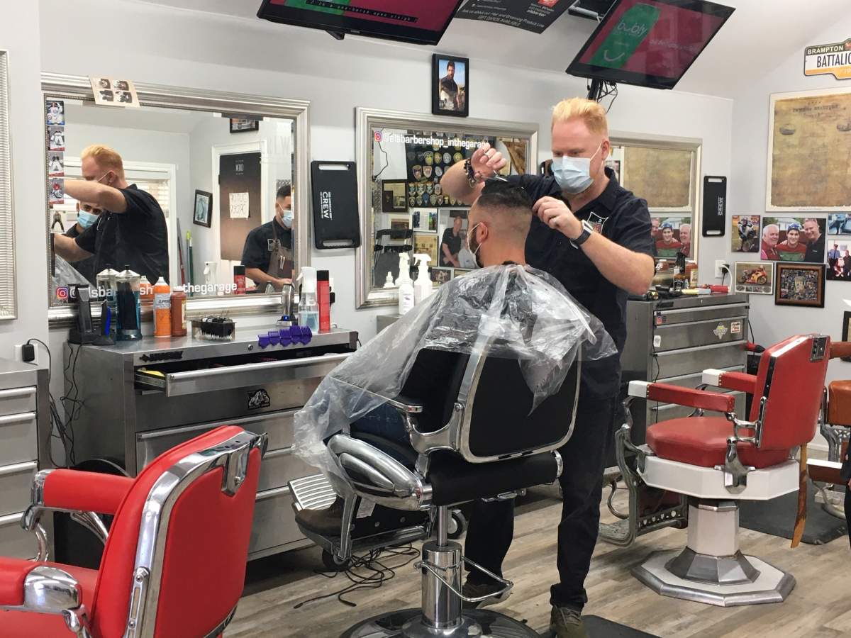 Rob Rutledge, Owner of Al’s Barbershop in Brampton, cuts a customer’s hair.