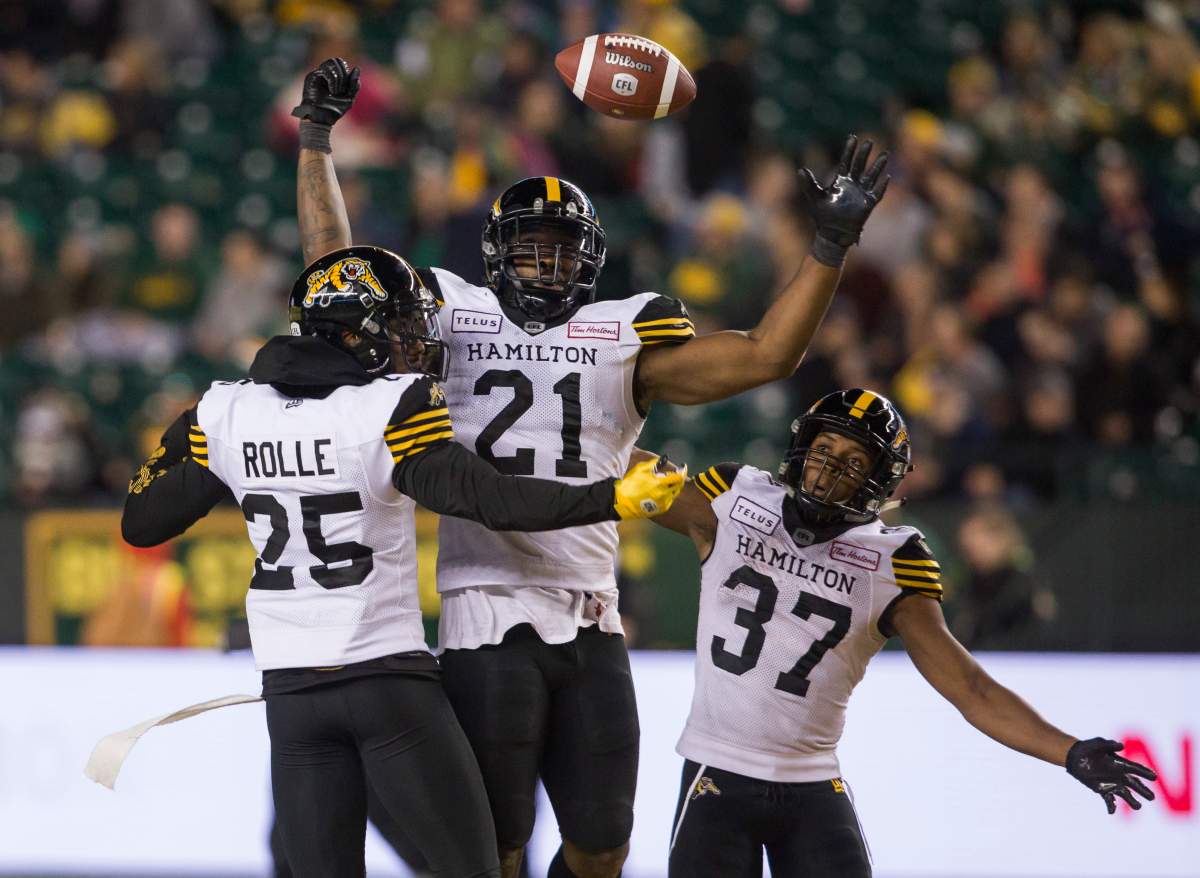 Hamilton Tiger-Cats defensive back Jumal Rolle (25), linebacker Simoni Lawrence (21) and defensive back Frankie Williams (37) celebrate an interception on the Edmonton Eskimos during second half CFL action in Edmonton, Alta., on Friday September 20, 2019. The Tiger-Cats won 30-27.