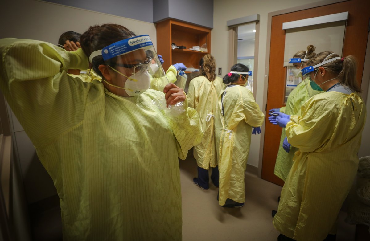 Nurses putting on personal protective equipment (PPE) before treating COVID-19 patients in the intensive care unit at the Peter Lougheed hospital in Calgary on Nov. 14, 2020.