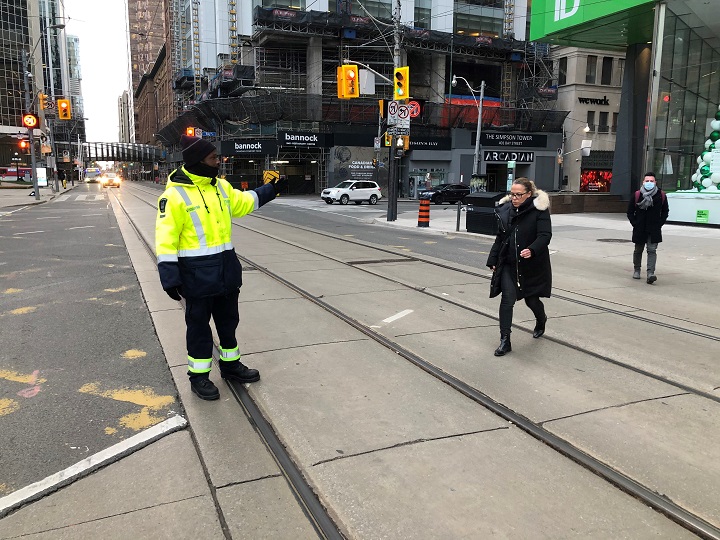 A traffic agent managing the Queen Street West and Bay Street intersection in Toronto.