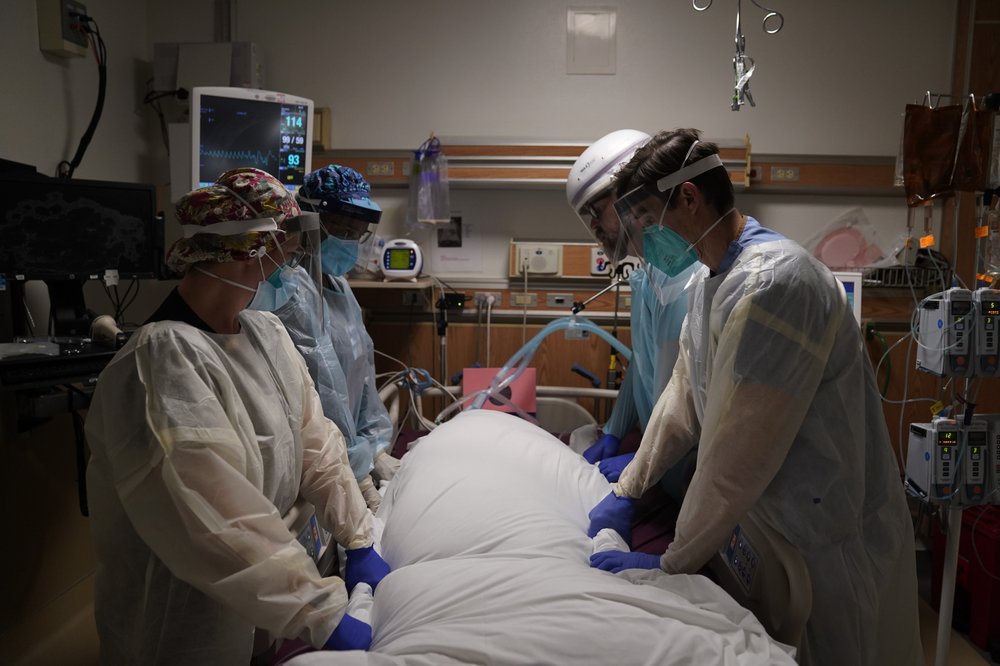 Medical workers prepare to manually prone a COVID-19 patient in an intensive care unit at Providence Holy Cross Medical Center in the Mission Hills section of Los Angeles, Tuesday, Dec. 22, 2020.