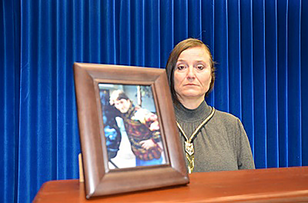 A photo from the RCMP showing Paulina with a photo of her brother, Joseph Pek.