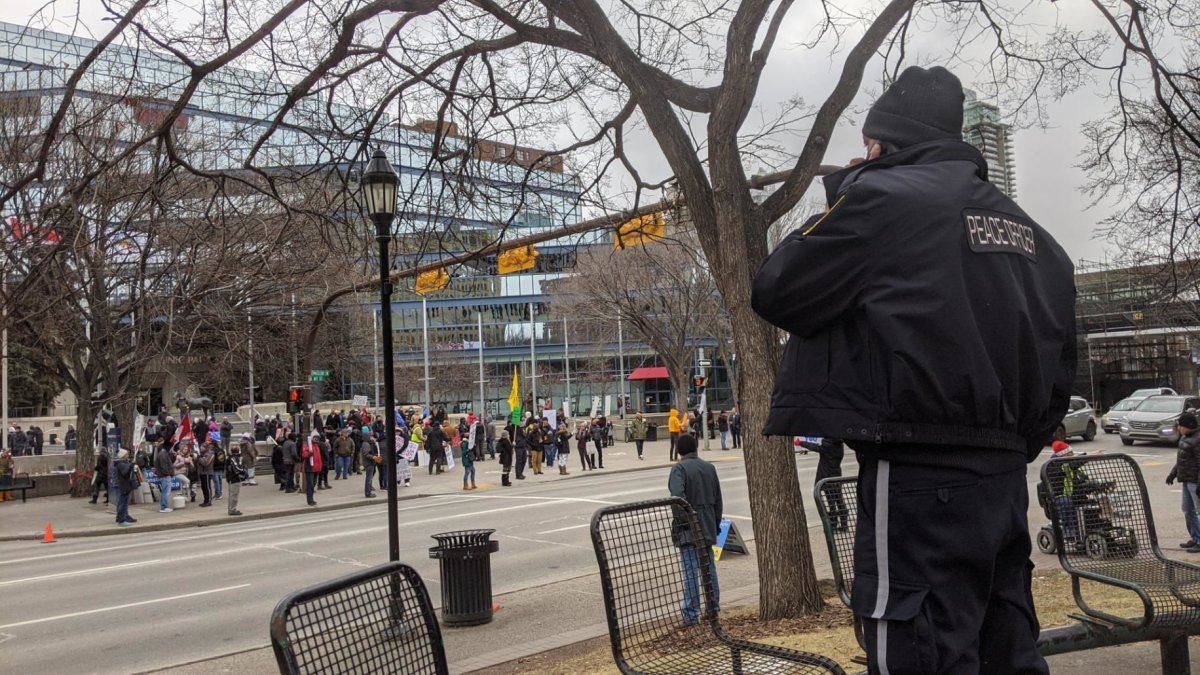 A peace officer watches as another rally is held in Calgary to protest government COVID-19 restrictions, Saturday, Dec. 12, 2020. 