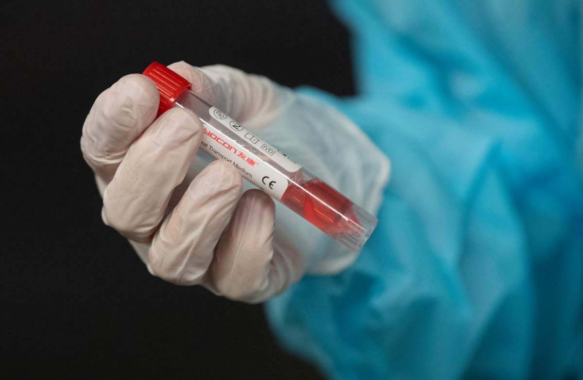 A nurse holds a vial containing a patients test swab at a drive-thru Covid-19 testing centre at the National Arts Centre Wednesday, Nov. 18, 2020 in Ottawa.