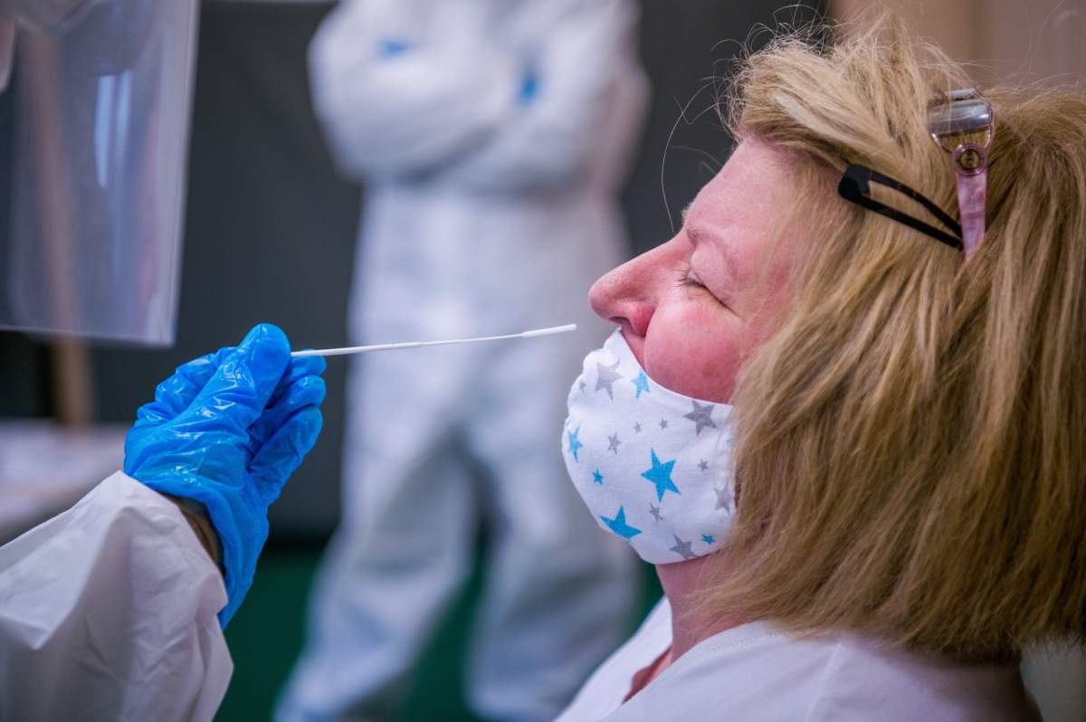 A medical student takes a COVID-19 test swab sample from a staff member at a kindergarten in Budapest, Hungary, Nov. 30, 2020.