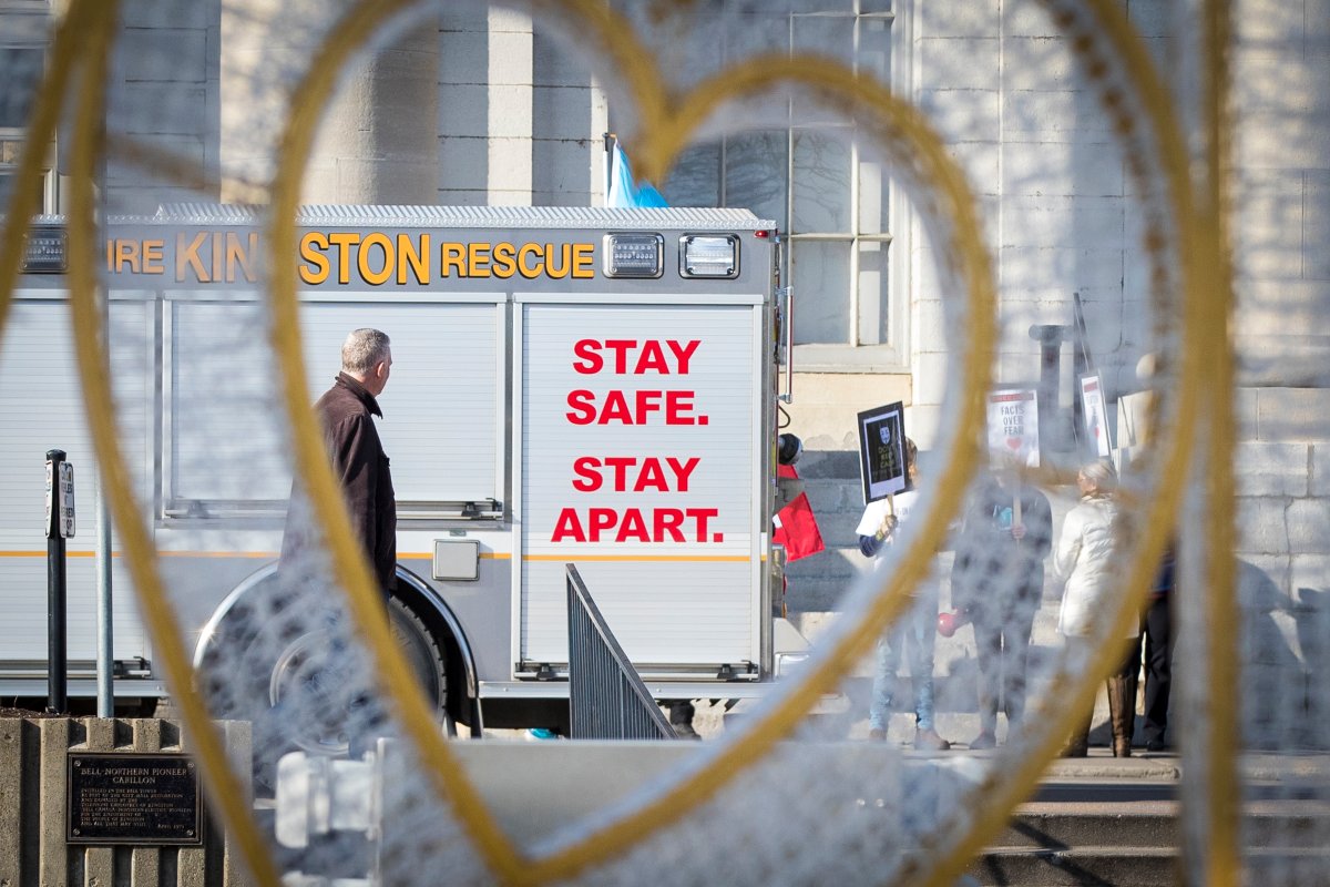 A firetruck with "Stay safe, stay apart" is seen through a heart during an anti-lockdown protest in Kingston, Ontario on Sunday, November 29, 2020, as the COVID-19 pandemic continues across Canada and around the world. THE CANADIAN PRESS IMAGES/Lars Hagberg.