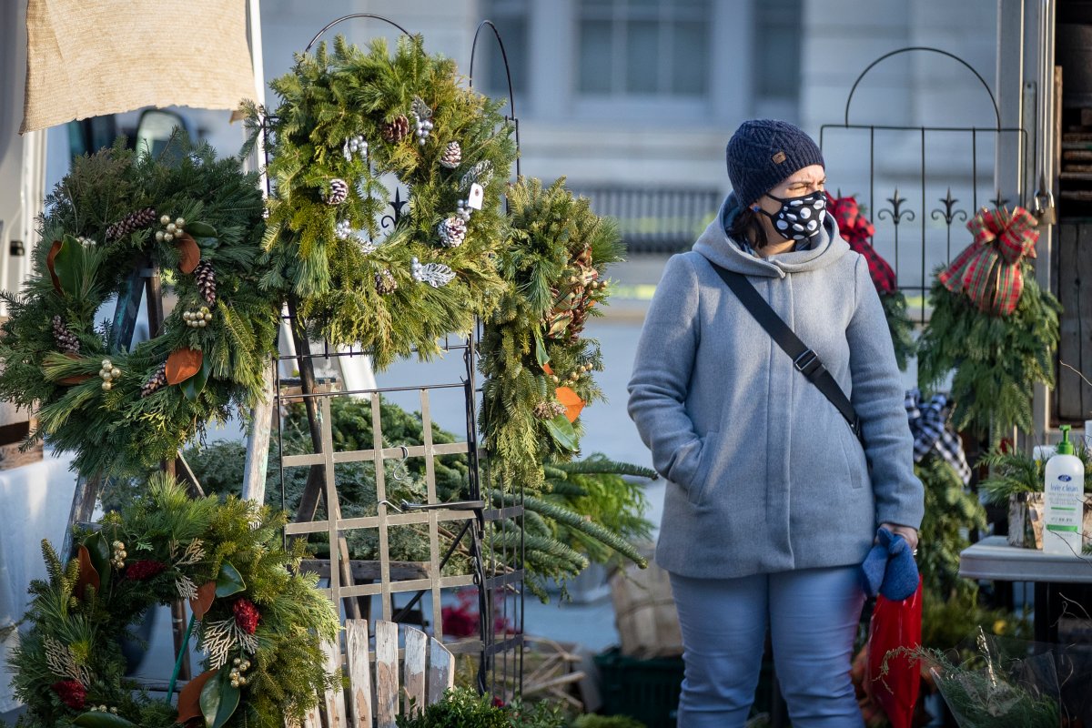 A person wears a mask while looking at Christmas wreaths in Kingston, Ontario on Saturday, November 28, 2020, as the COVID-19 pandemic continues across Canada and around the world. THE CANADIAN PRESS IMAGES/Lars Hagberg.