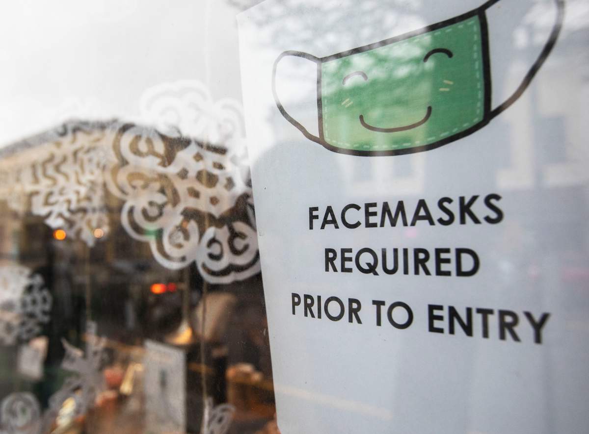 A sign letting customers know they must wear a mask inside is seen in a business' window in downtown Victoria, B.C. on Monday, Dec. 7, 2020. Masks are required in all indoor public spaces in B.C. THE CANADIAN PRESS/Marissa Tiel.