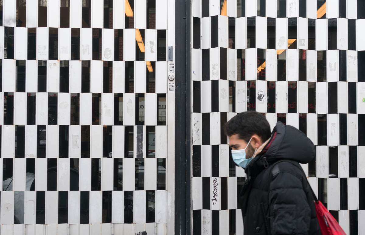 A man walks past a closed shop during the COVID-19 pandemic in Montreal, on Friday, December 11, 2020. 