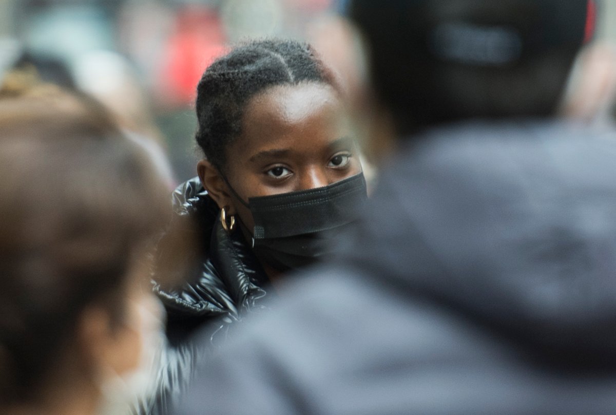 People wear face masks as they walk along a street in Montreal, Sunday, December 13, 2020, as the COVID-19 pandemic continues in Canada and around the world. 