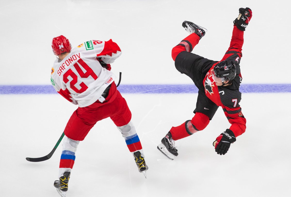 Canada's Kirby Dach (7) is checked by Russia's Ilya Safonov (24) during third period IIHF World Junior Hockey Championship pre-competition action in Edmonton on Wednesday, December 23, 2020. 