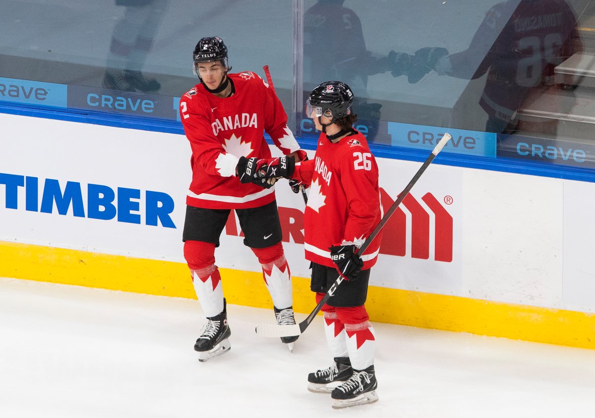 Canada's Braden Schneider (2) and Philip Tomasino (26) celebrate a goal against Switzerland during first period IIHF World Junior Hockey Championship action in Edmonton on Tuesday, December 29, 2020. 
