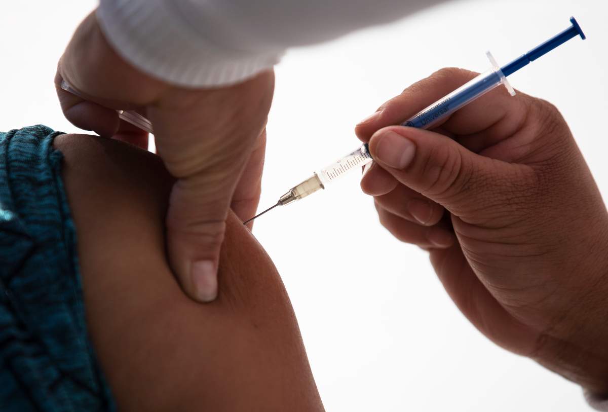 A health worker gets a shot of the Pfizer-BioNTech vaccine for COVID-19 at the N-1 military base in Mexico City, Wednesday, Dec. 30, 2020.