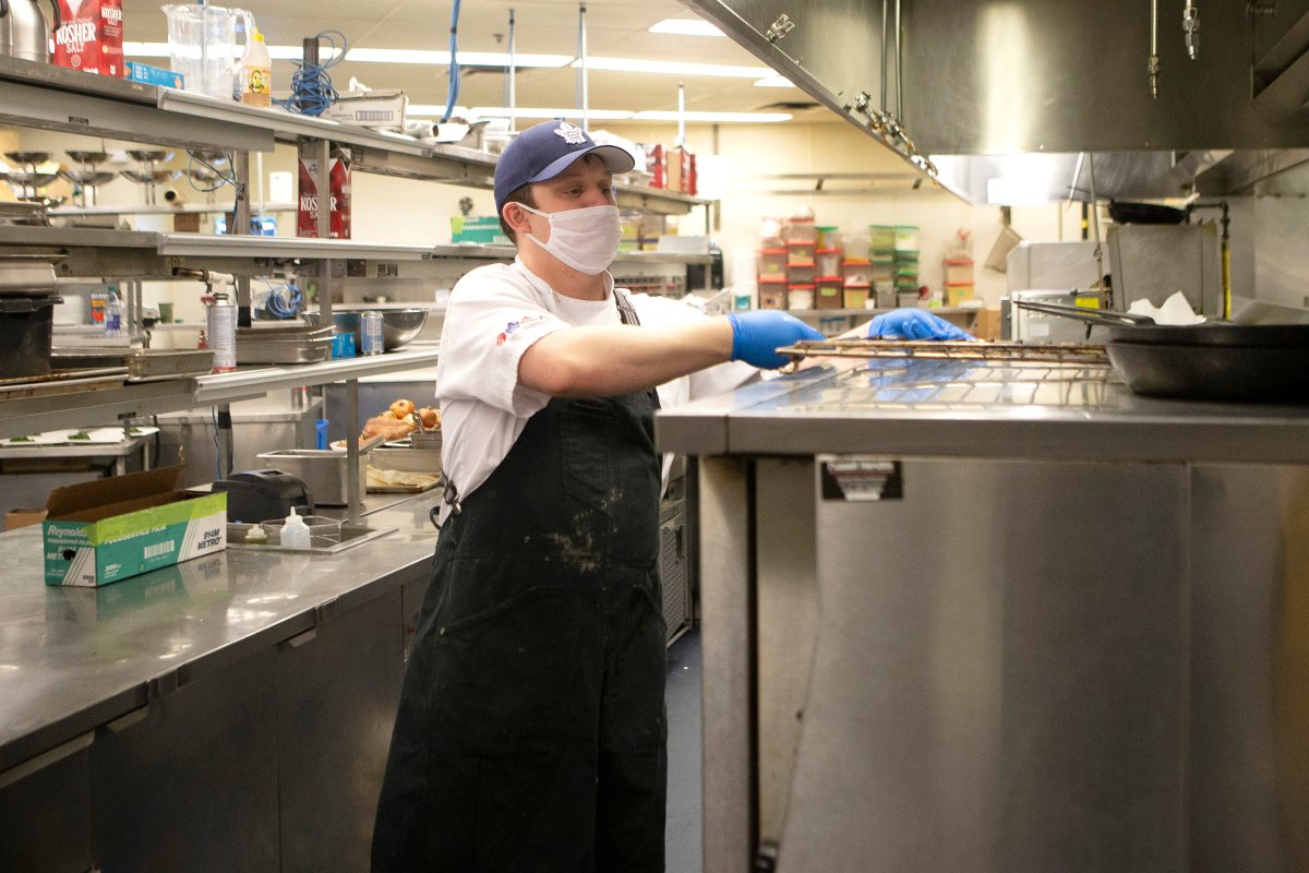 An MLSE employee works in the kitchen at the Scotiabank Arena, making meals which are packaged in the stadium's arena floor, in Toronto on Wednesday, April 22, 2020. The meals are being donated as part of an initiative with partners such as Second Harvest, and are being distributed to front-line workers and homeless shelters during the COVID-19 pandemic.