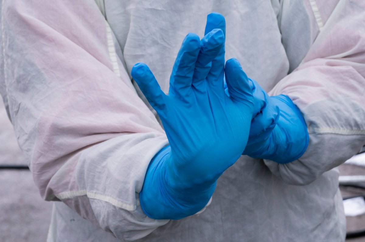 A nurse slips on protective gloves at a drive-through clinic at Ste-Justine Children Hospital in Montreal, on Wednesday, April 1, 2020. 