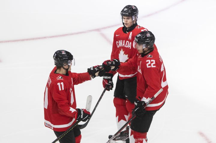 Canada's Cole Perfetti (11), Dylan Cozens (22) and Connor McMichael (17) celebrate a goal against Switzerland during second period IIHF World Junior Hockey Championship action in Edmonton on Tuesday, December 29, 2020. 