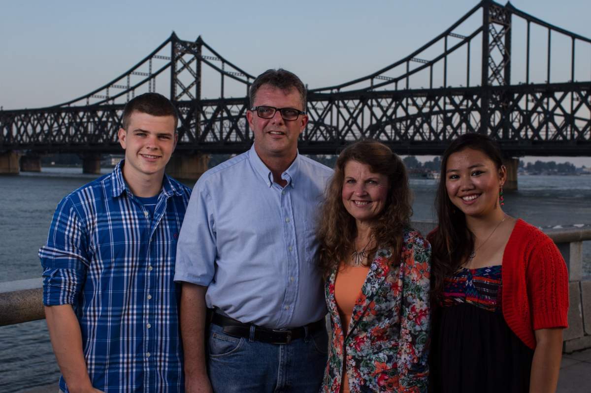 Kevin and Julia Garratt and family pose in front of the “Friendship Bridge” that links China to North Korea, in 2014.