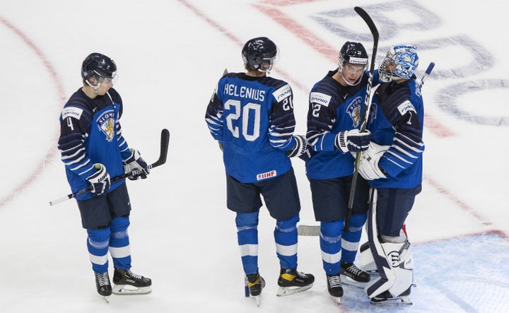 Finland's Ville Heinola (4), Samuel Helenius (20), Matias Rajaniemi (12) and goalie Kari Piiroinen (1) celebrate the win over Slovakia during IIHF World Junior Hockey Championship action in Edmonton on Wednesday, December 30, 2020. 