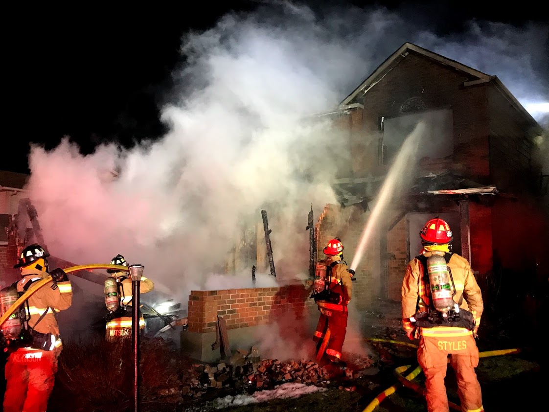 Firefighters work to extinguish a fire at a house on Hansen Avenue.