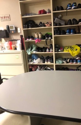 The nurse says the table provided for staff to eat at is next to a wall of shoes that staff leave so that they don’t transmit anything at home.