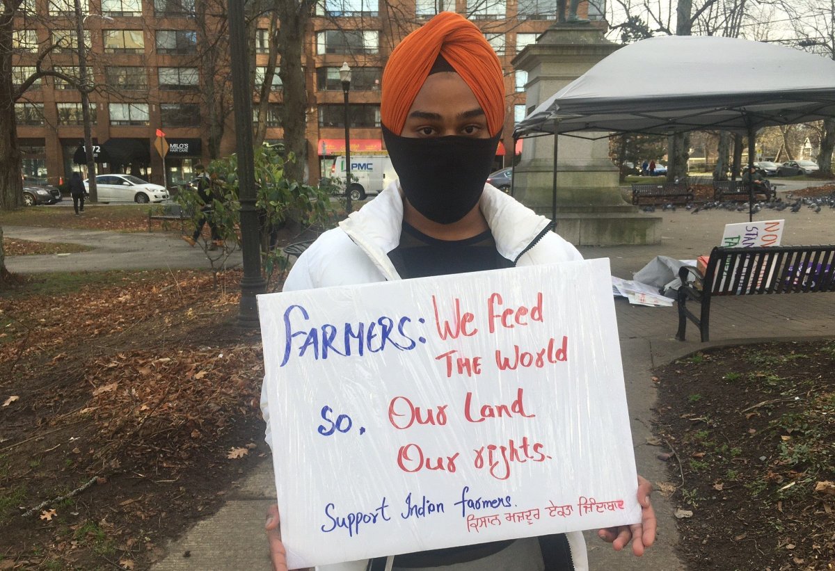 A protestor is holding a sign in Halifax in solidarity with Indian farmers protesting new agriculture laws. 