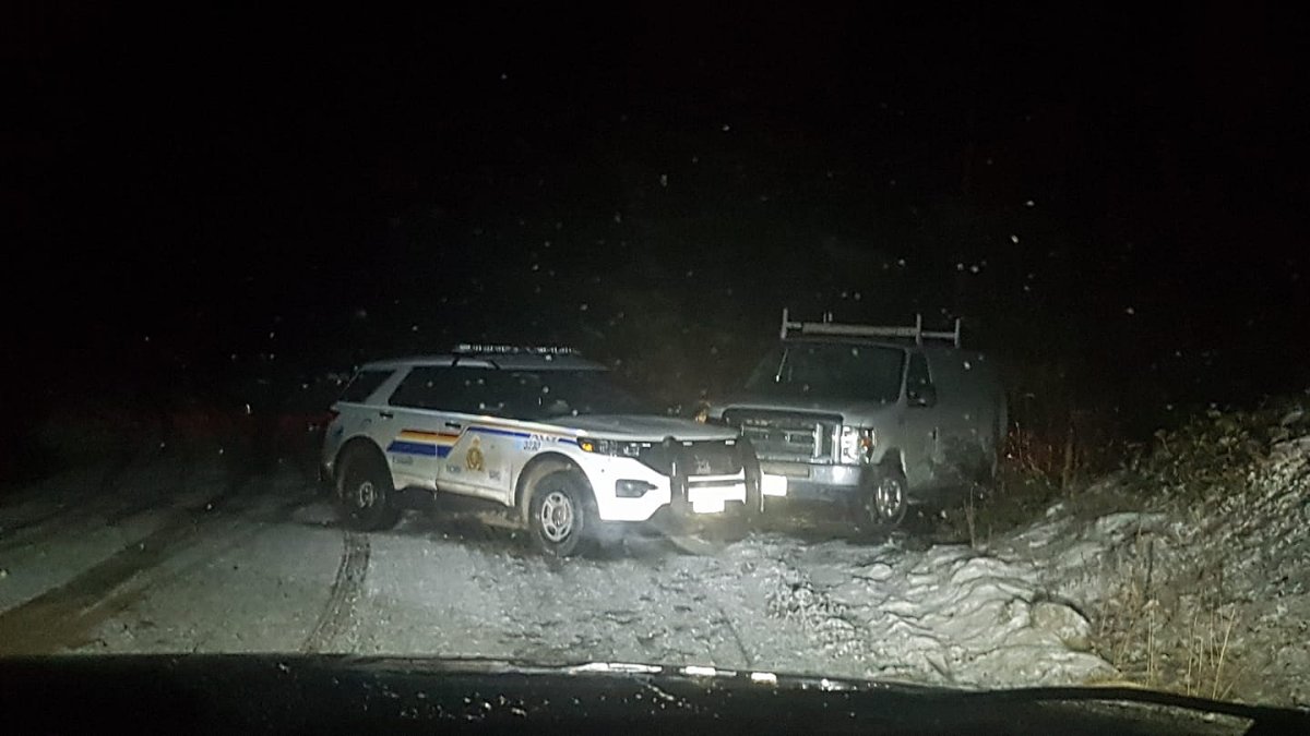 An RCMP vehicle is parked in front of a white van found along Postill Lake Road on Tuesday night. It’s believed to be the same van that was used in the theft of an ATM in Lake Country earlier in the day.