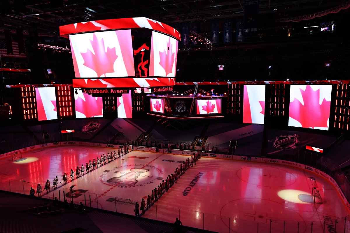 Toronto Maple Leafs and Montreal Canadiens players stand for the Canadian national anthem prior to NHL exhibition hockey action ahead of the Stanley Cup playoffs in Toronto on Tuesday, July 28, 2020.