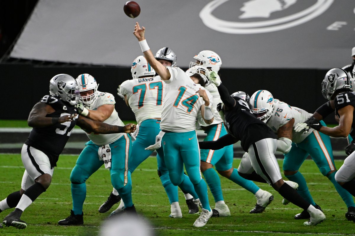 Las Vegas Raiders defensive end Arden Key (99) commits a roughing the passer penalty on Miami Dolphins quarterback Ryan Fitzpatrick (14) during the second half of an NFL football game, Saturday, Dec. 26, 2020, in Las Vegas.