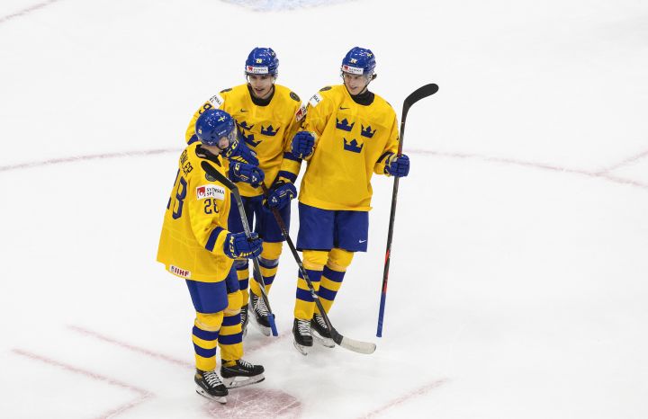 Sweden's Noel Gunler (28), Albin Sundsvik (29) and Oskar Olausson (24) celebrate a goal against Austria during first period IIHF World Junior Hockey Championship action in Edmonton on Monday, December 28, 2020. 