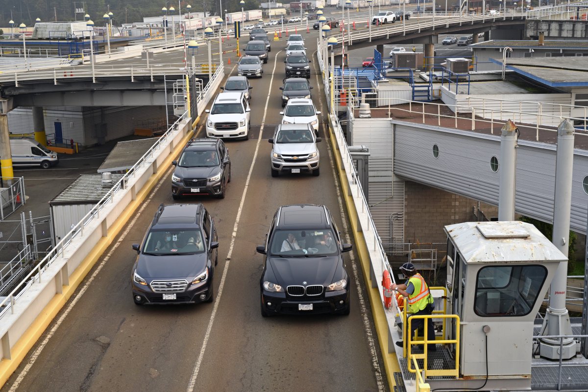 A worker watches as cars drive on to a BC Ferries vessel at the Swartz Bay Terminal in Sidney, British Columbia on September 17, 2020.  