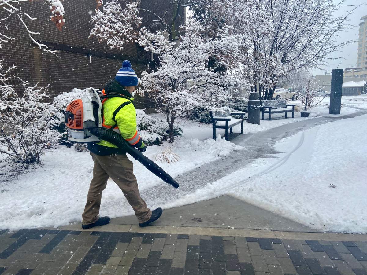 A contractor blows snow off of city sidewalks in Penticton, B.C., on Monday, Dec 21., 2020.